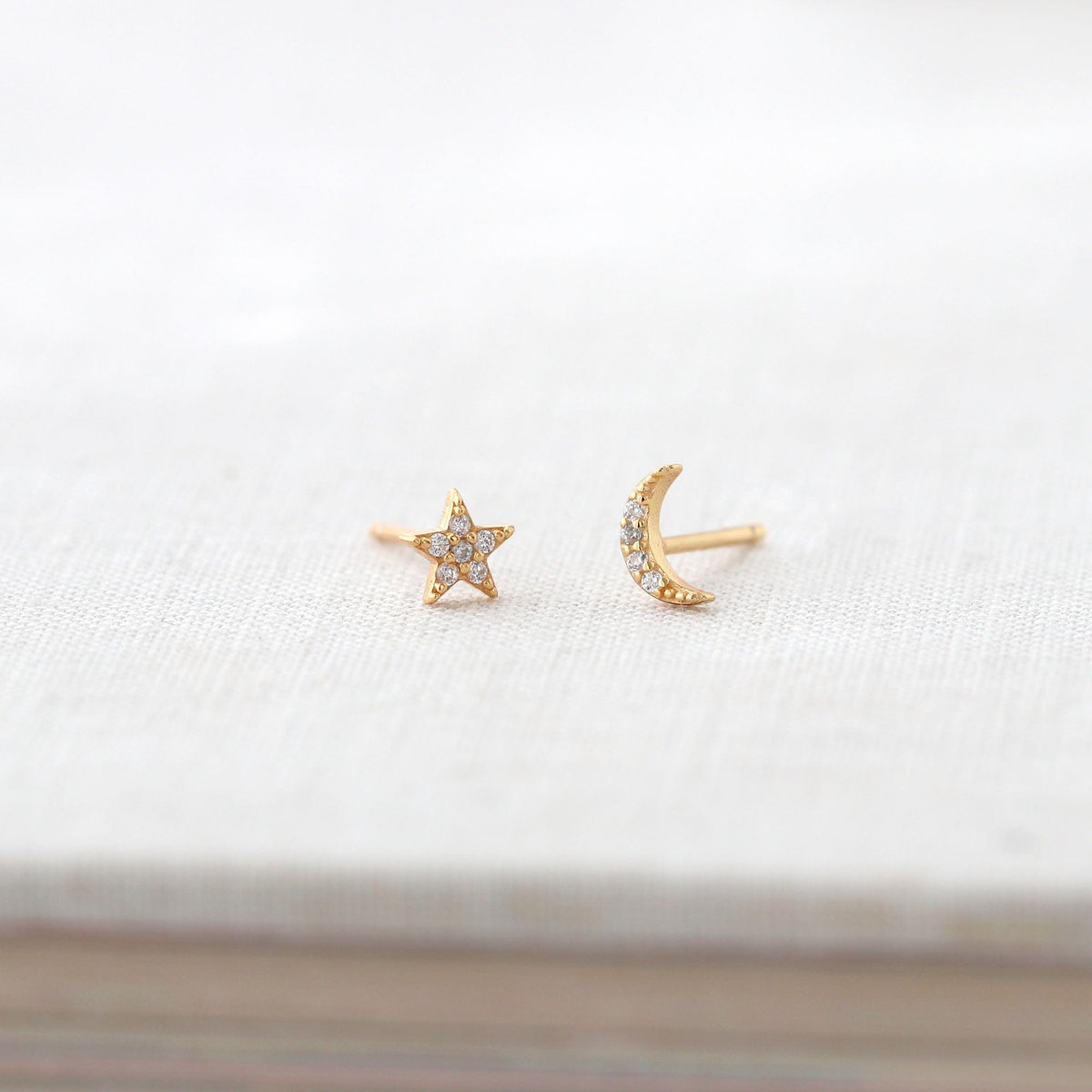 Star and Moon Crystal Stud Earrings in 18K gold vermeil on a white book