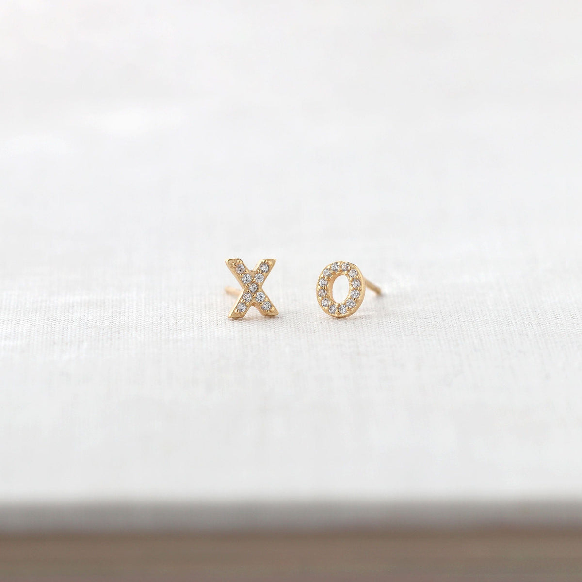 XO Crystal Stud Earrings in 18K gold vermeil on a white book