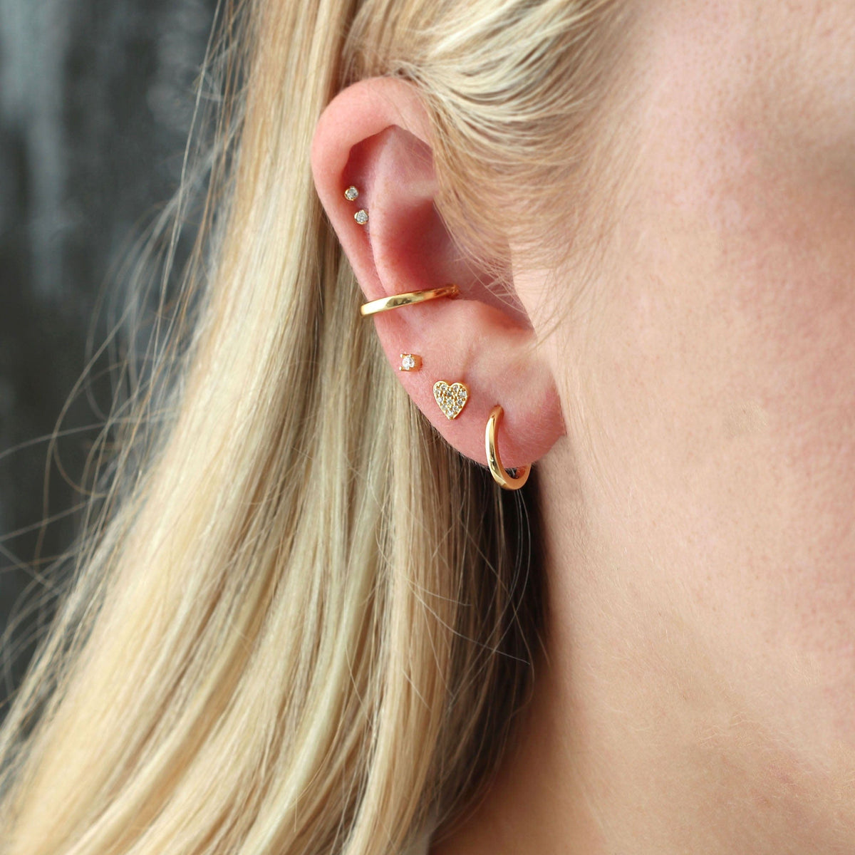 Classic Huggie Hoop worn in a gold ear stack with the Round Ear Cuff, Crystal Stud and Heart Crystal Stud