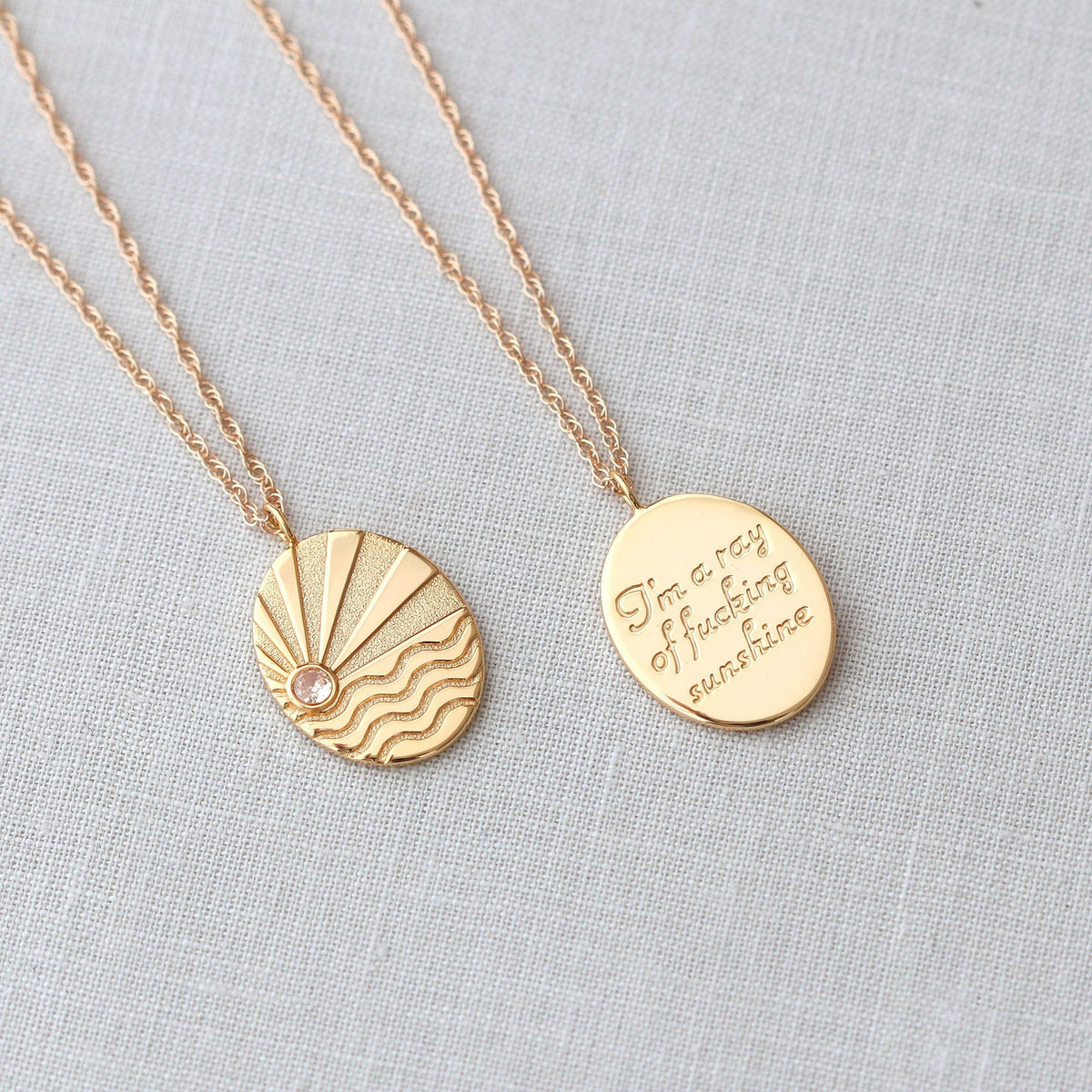 Ray of Sunshine Charm Necklace front and back, a sun rising over waves and engraved I'm a ray of f-ing sunshine