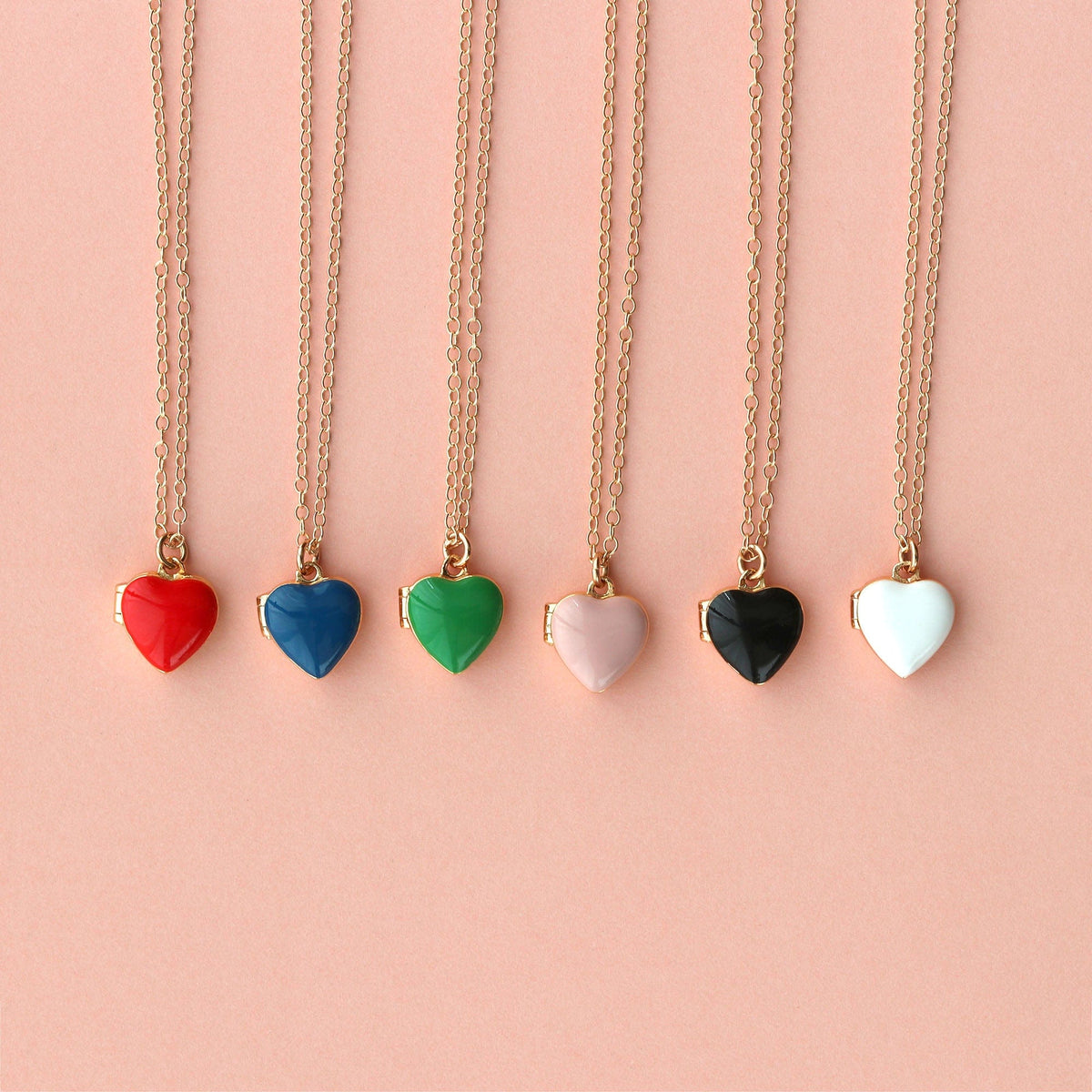 Enamel Heart Lockets in red, navy, green, pink, black and white on a pink background