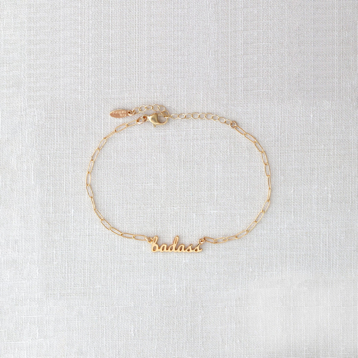 Gold Badass Bracelet with the word badass in script on a dainty chain