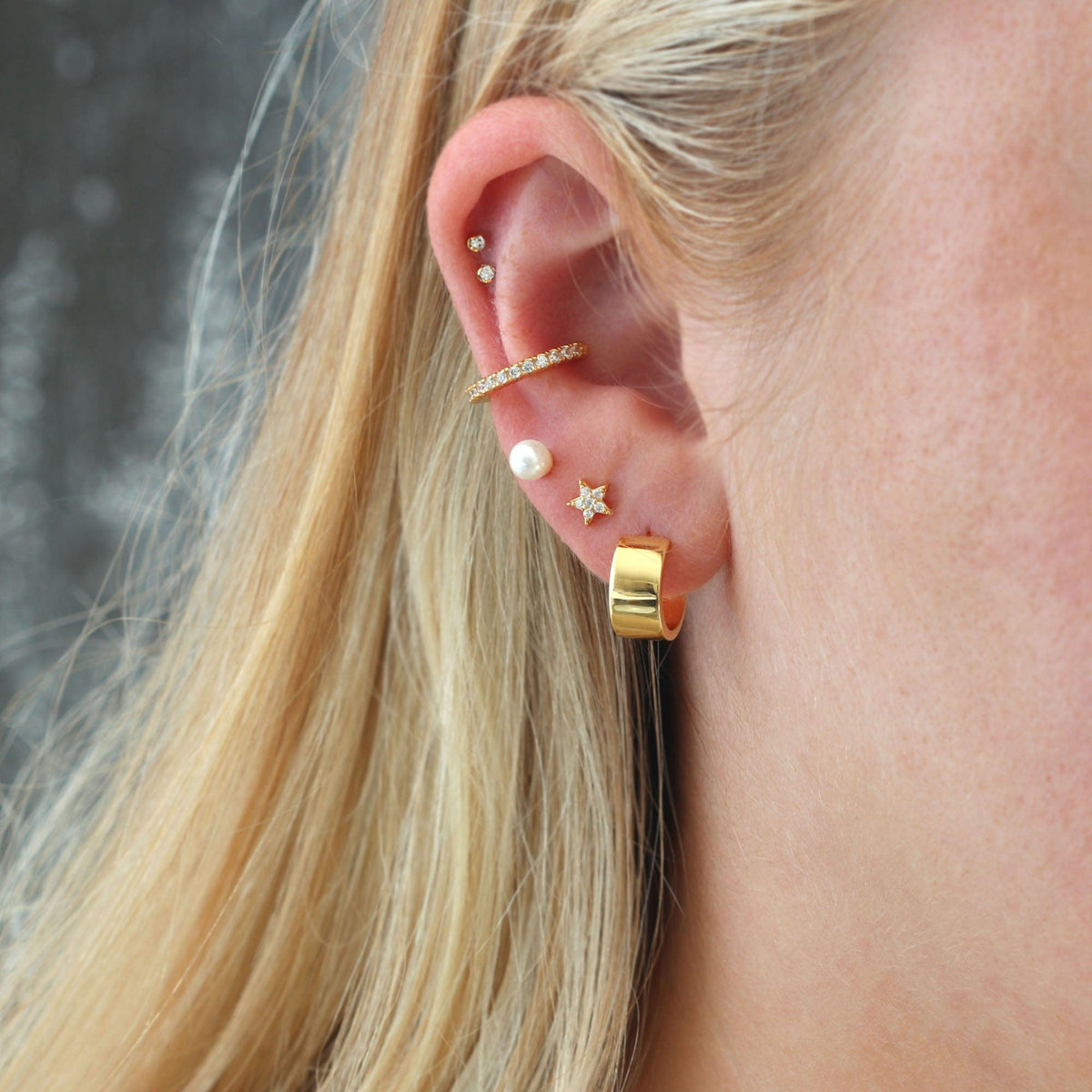 Gold Star Crystal Stud worn in an ear stack with a pearl stud, wide huggie and ear cuff