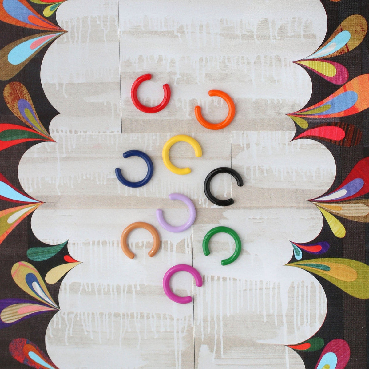 Palette Enamel Ear Cuffs in a rainbow of colors on a swirled background