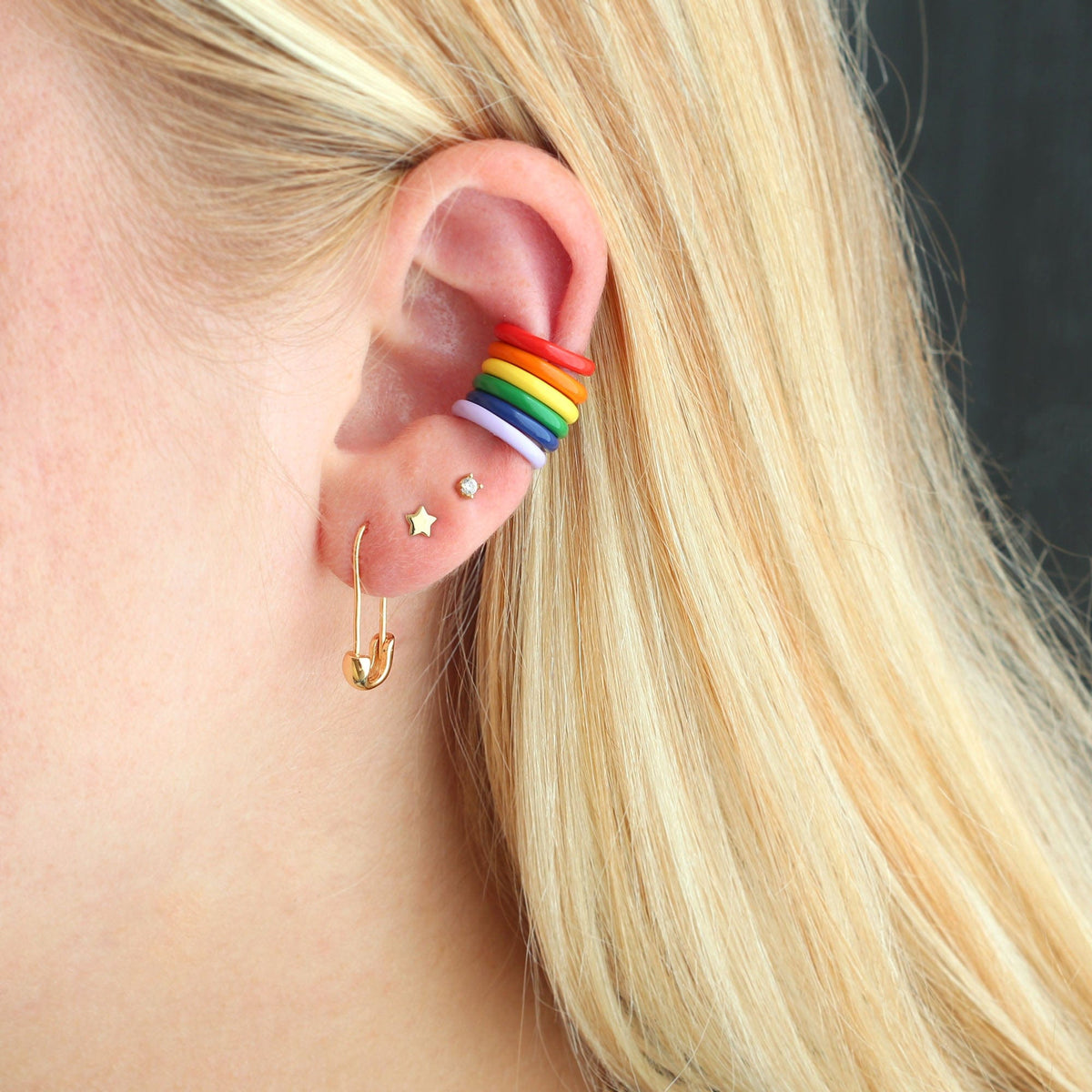Gold Classic Safety Pin Hoop worn in an ear stack with rainbow enamel huggies