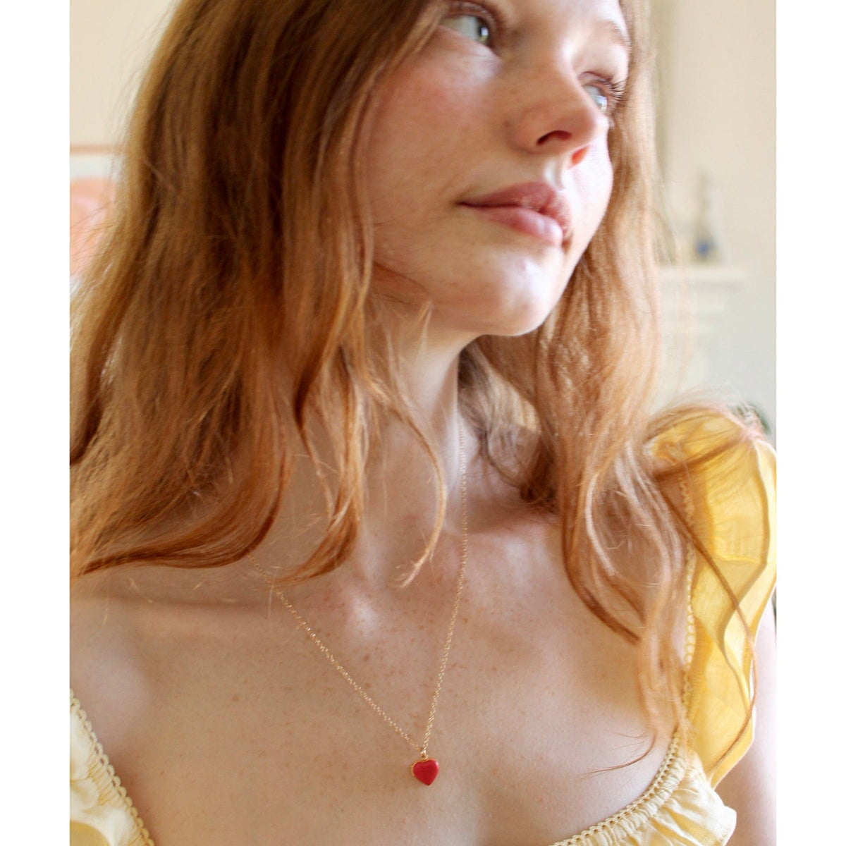 Woman with auburn hair wearing a red Enamel Heart Locket