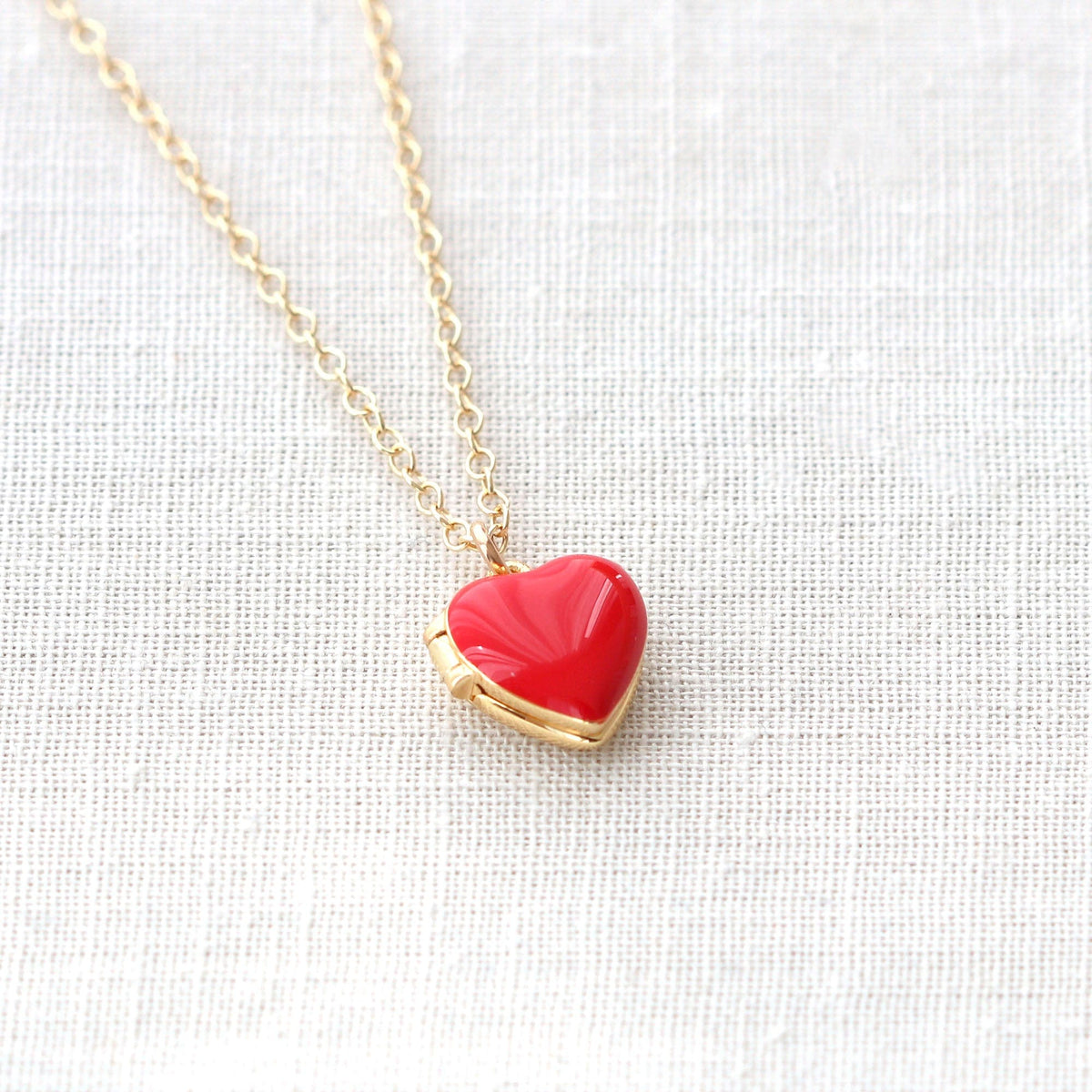 Red Enamel Heart Locket closed, on white linen