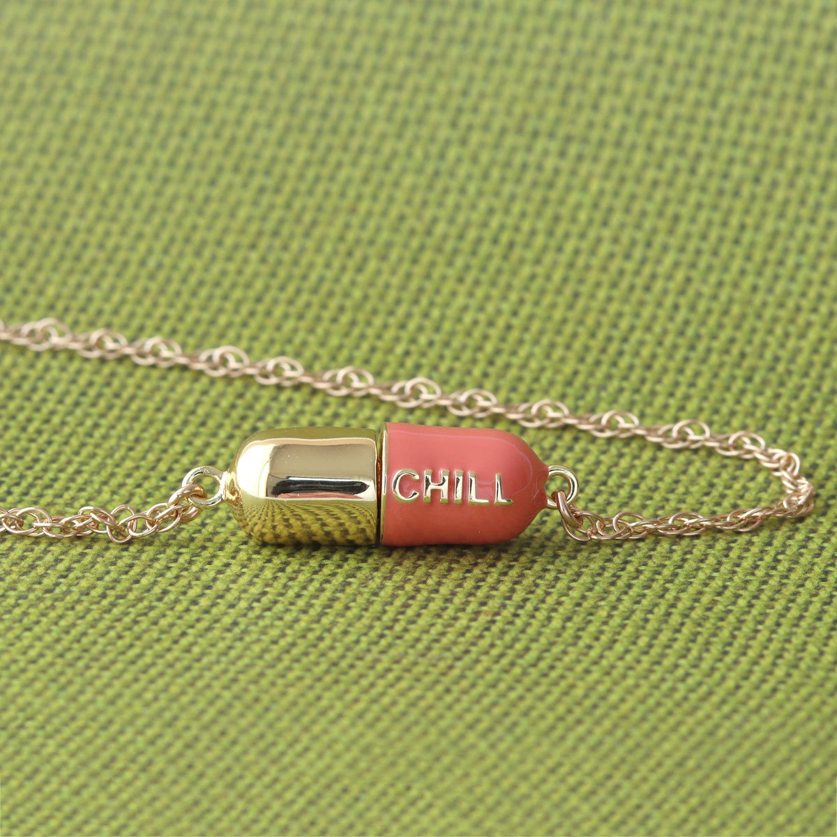 Coral Big Chill Pill Chain Necklace on green fabric
