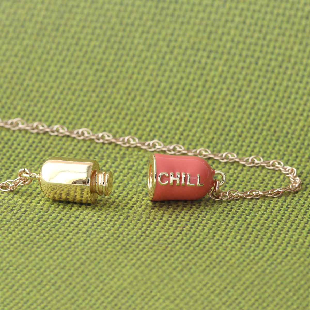 Coral Big Chill Pill opened into two halves on green fabric