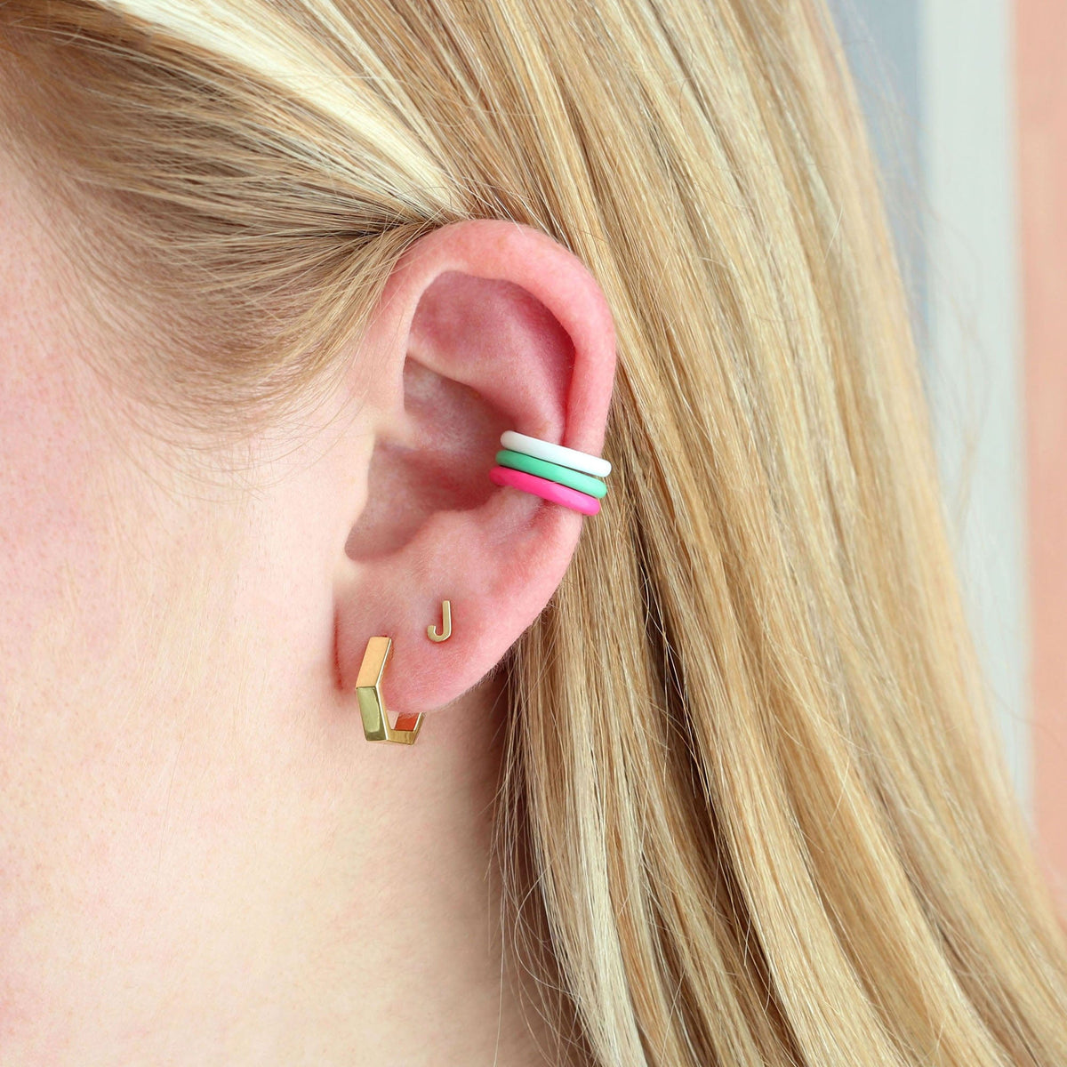 Gold Single Letter Stud worn with a green and white enamel ear cuff