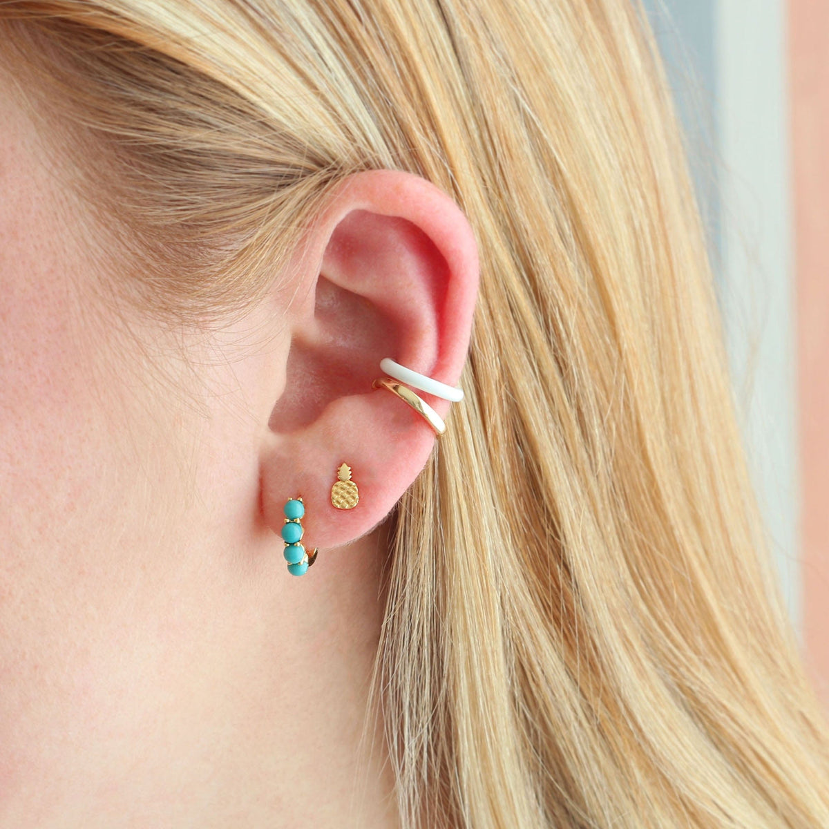 Gold Pineapple Stud worn in an ear stack with turquoise enamel huggies and an ear cuff