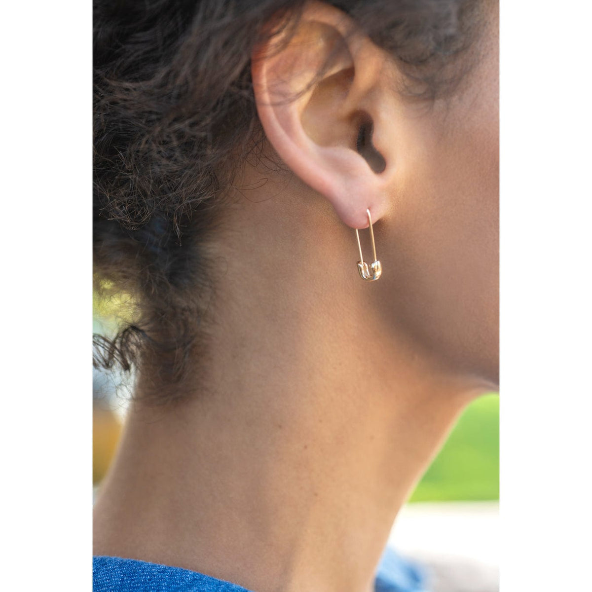 Close-up of an ear wearing a sterling silver Classic Safety Pin Hoop