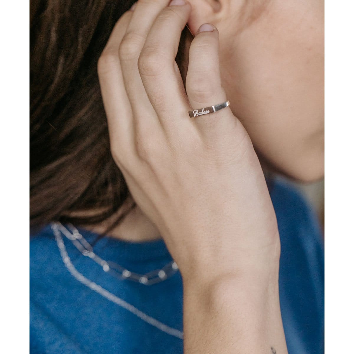Hand at the face wearing the sterling silver Badass Script Engraved Ring
